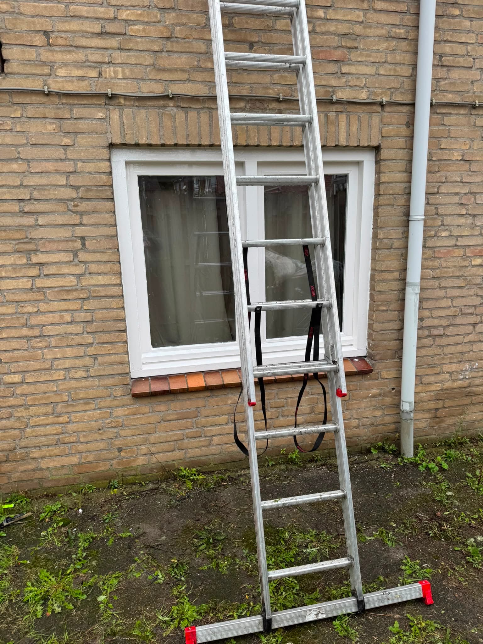 Nieuw wit kozijn gemonteerd in een bakstenen gevel