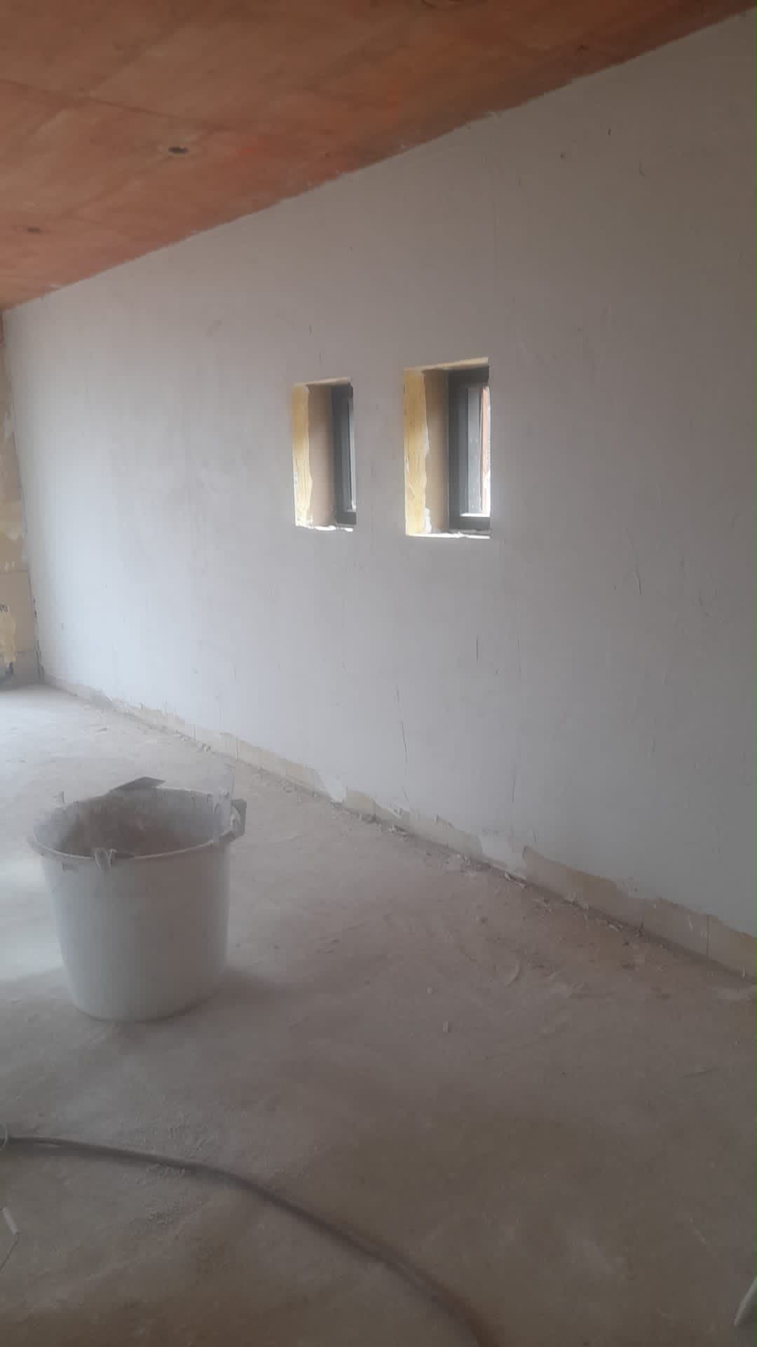 Gepleisterde wand met raamnissen tijdens het stucwerk