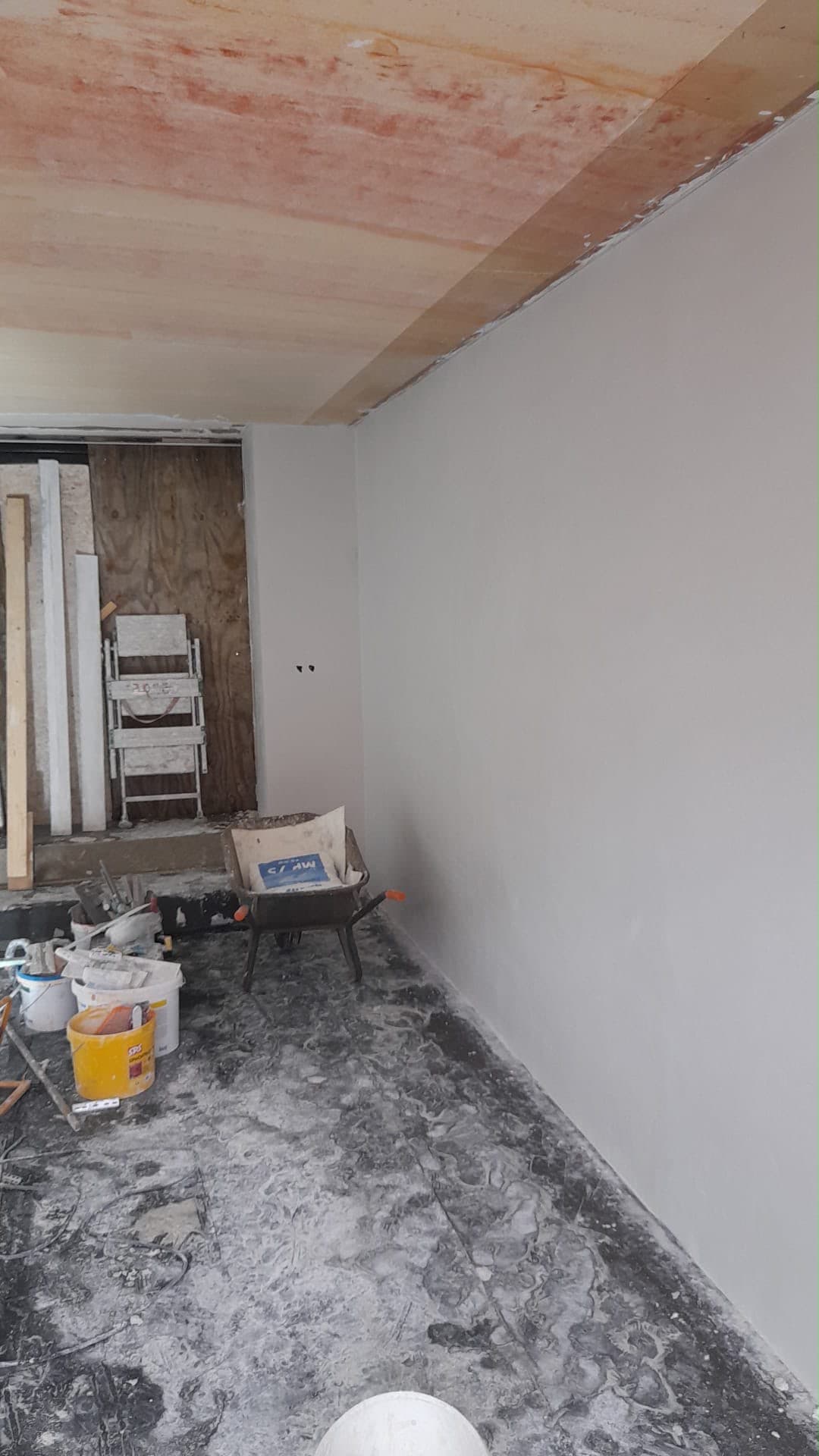 Glad gestucte witte wand tijdens een renovatie